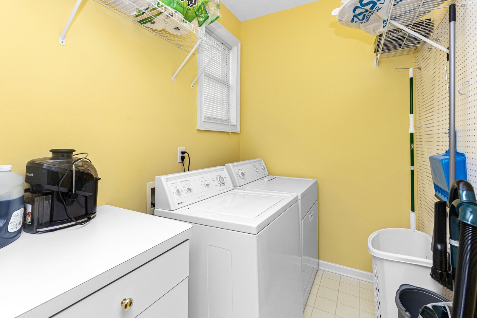 Bright, organized laundry room with washer and dryer and open shelving