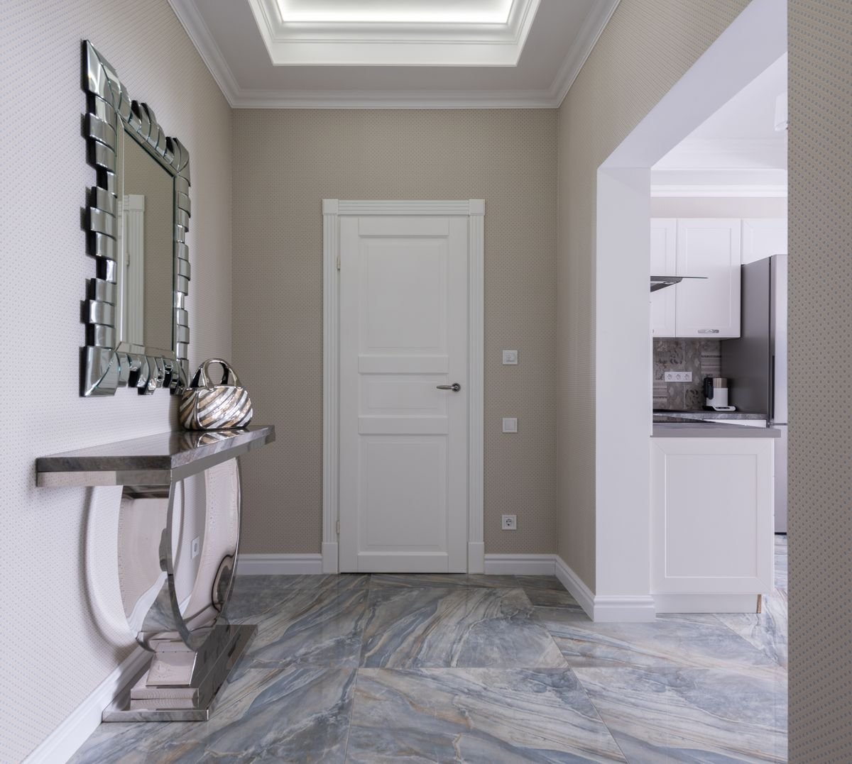 Modern hallway with a slim console table and a large mirror next to the front door