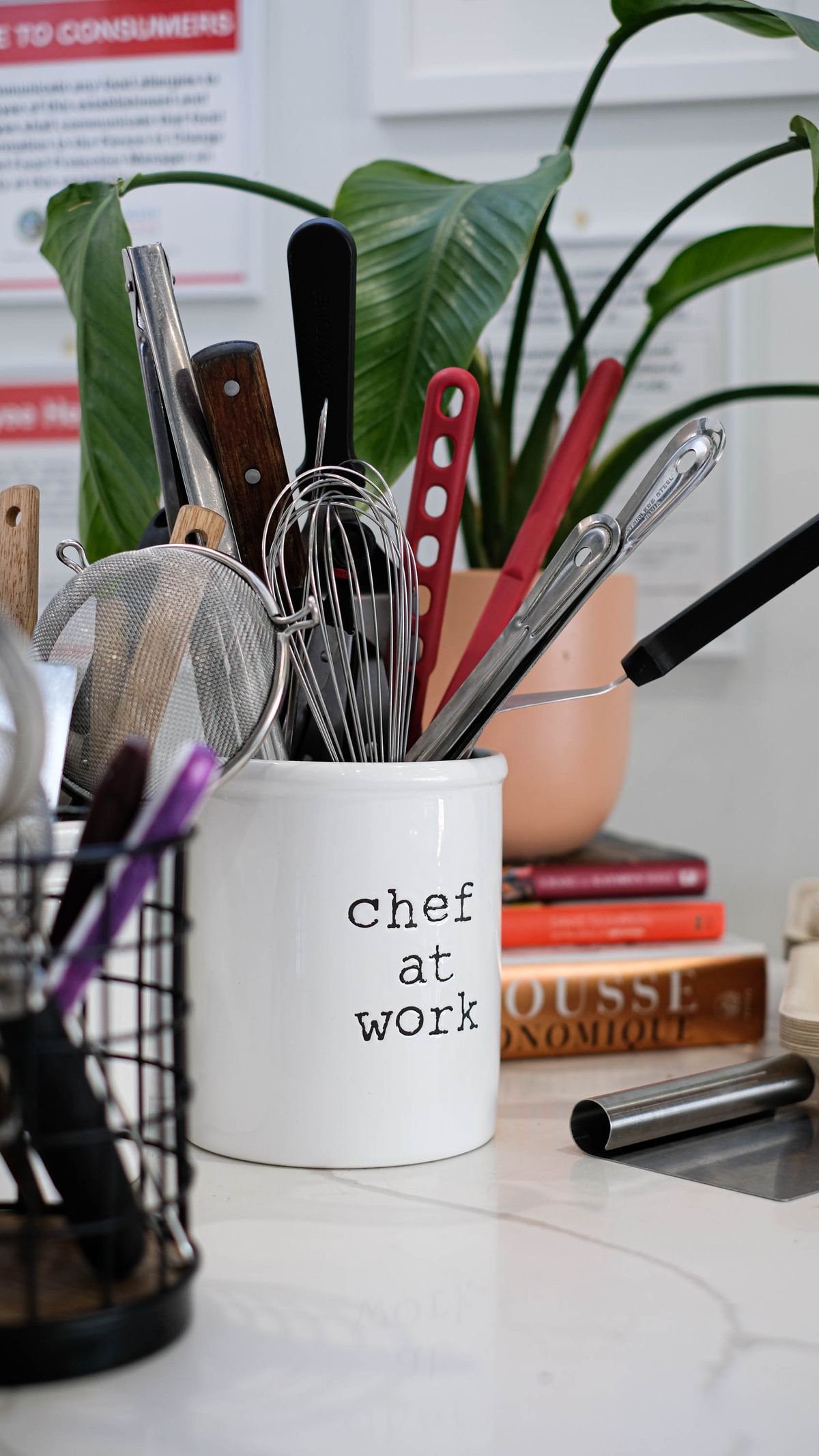 Countertop utensil crock filled with whisks, tongs and spatulas